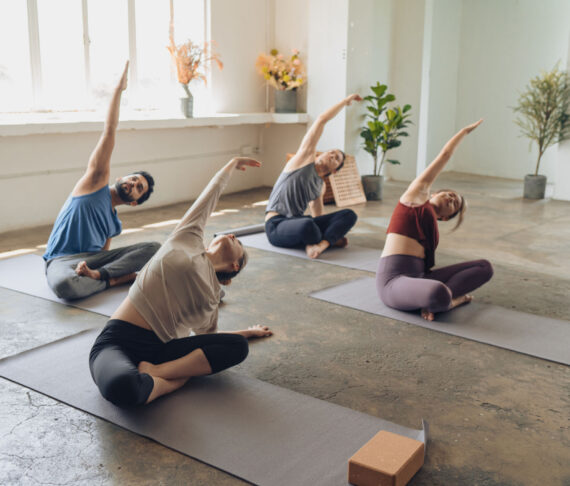 Asian yoga students observing and practicing during class Asian yoga students observing and practicing during class